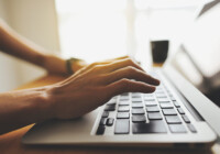 ノートパソコンと女性の手元